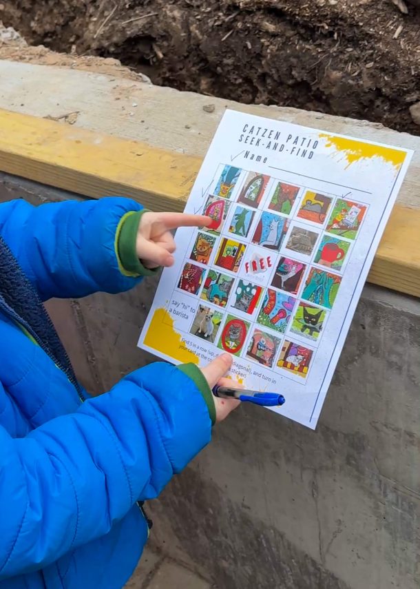 A kid showing a game on a piece of paper that was given at Catzen