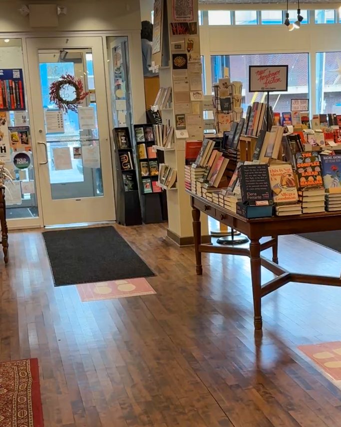 General view of the bookstore, showing the entrance and counters with stacks of books